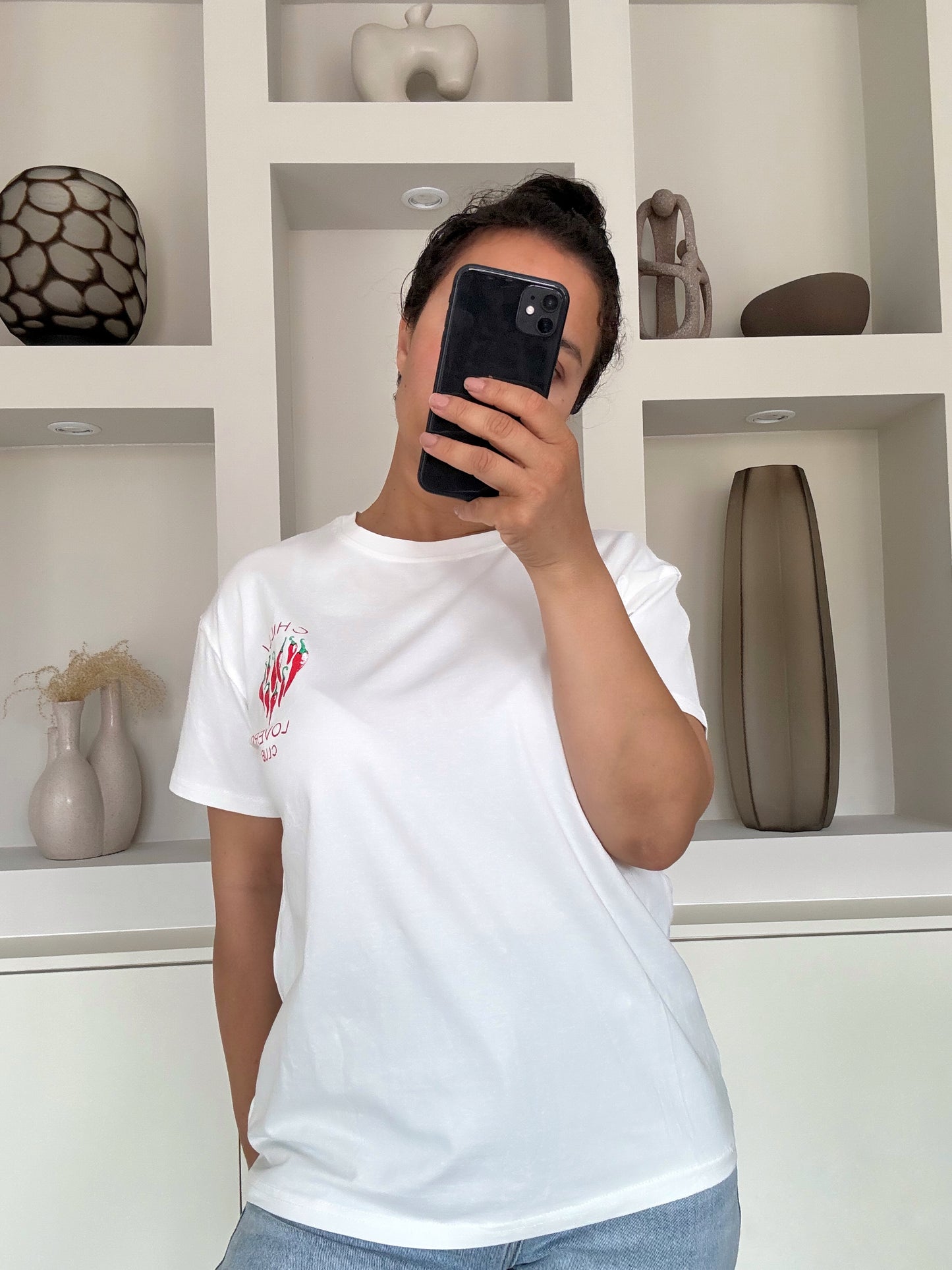 Model draagt de Chilli lovers club tee in wit met chili-illustratie op de borst – VYNAH