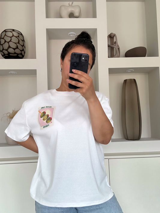 Model draagt The olive girl tee in wit met illustratie en tekst op zowel de voor- als achterkant – VYNAH