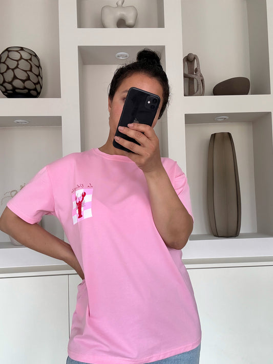 Model draagt de La dolce vita tee in zachtroze met speelse print op de borst – VYNAH