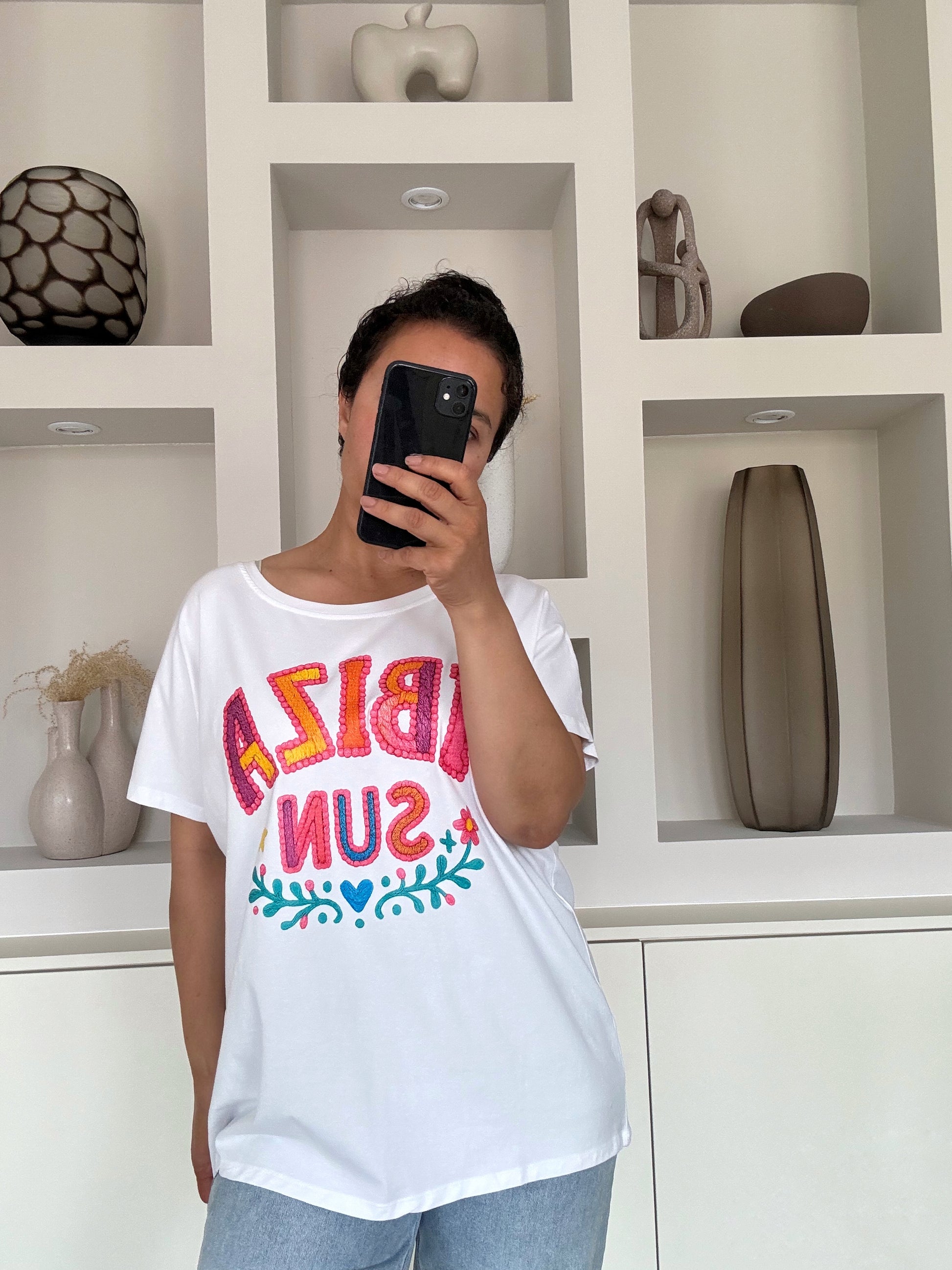 Model draagt de Ibiza sun tee in wit met kleurrijke print en relaxed fit – VYNAH