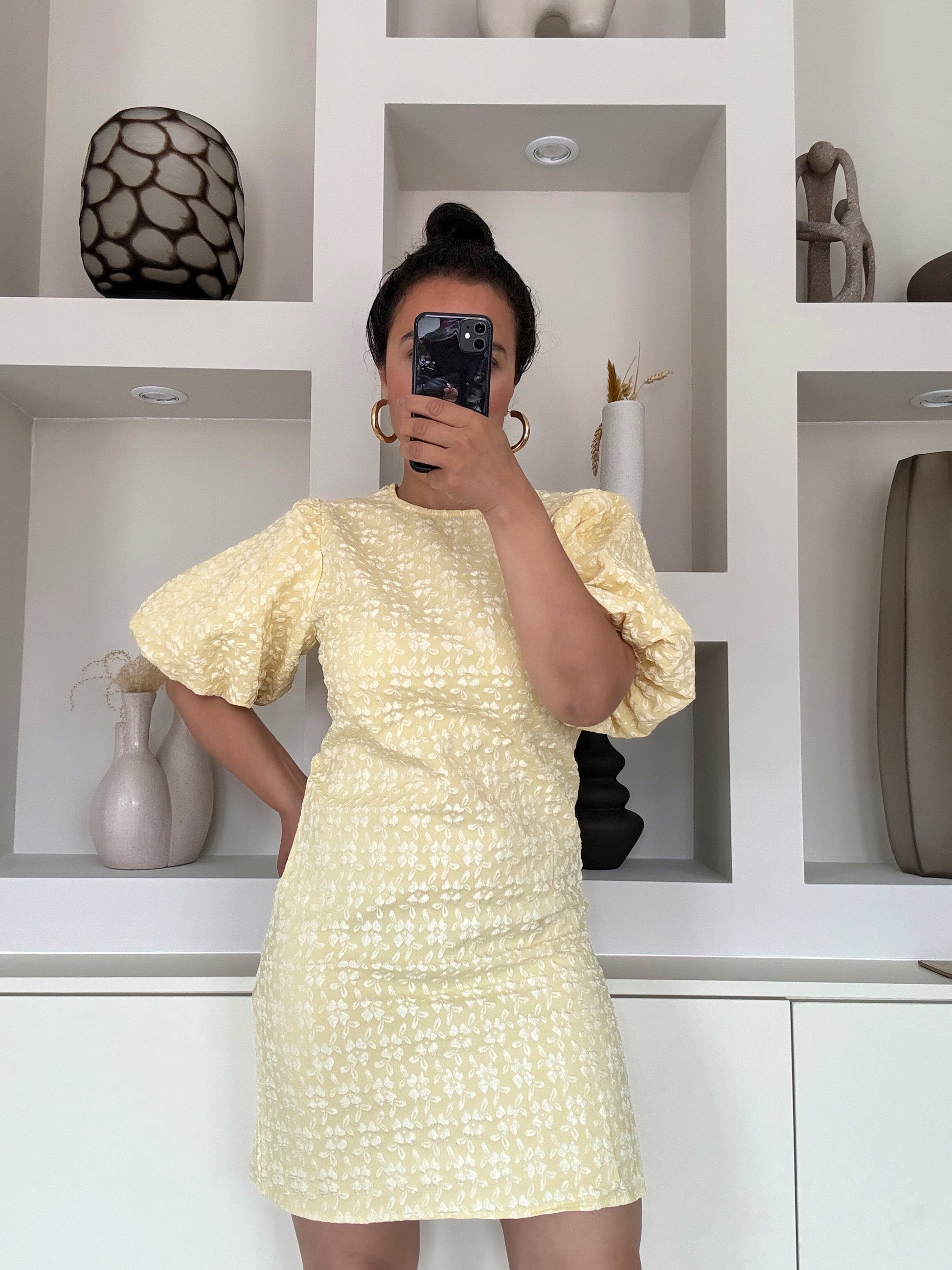 Model draagt de Yasmin Puff Dress in pastelgele bloemenprint met pofmouwen – VYNAH