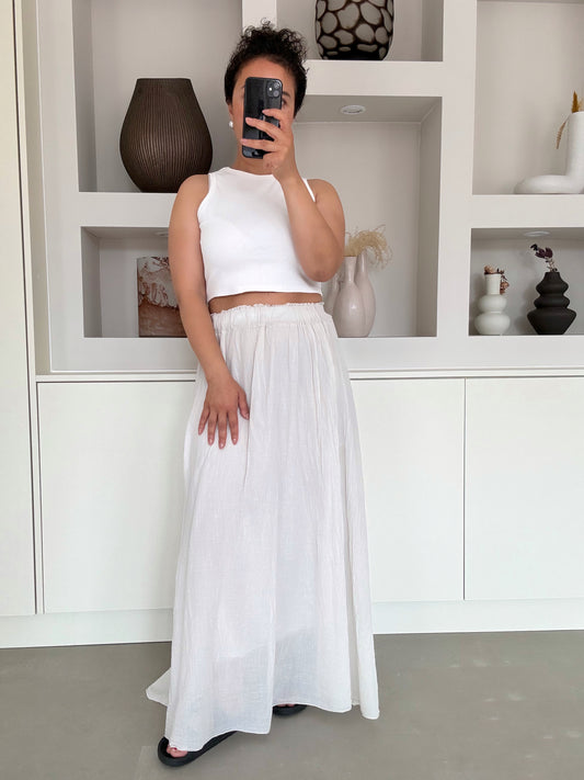 Model draagt de Lumi maxi skirt in zandkleur met elastische tailleband – VYNAH