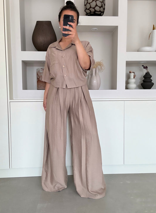 Model draagt de Liva wide set in soft taupe met cropped blouse en high waisted wide leg broek – VYNAH