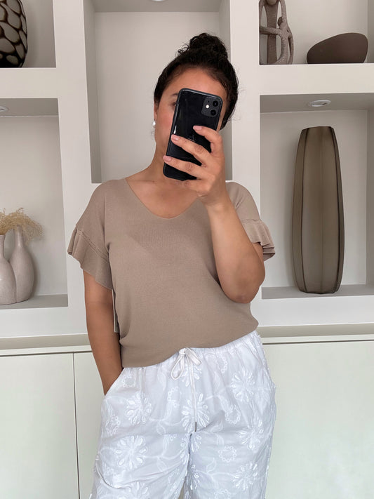 Model draagt de lina knit top in zandkleur met subtiele v-hals en geplooide mouw – VYNAH