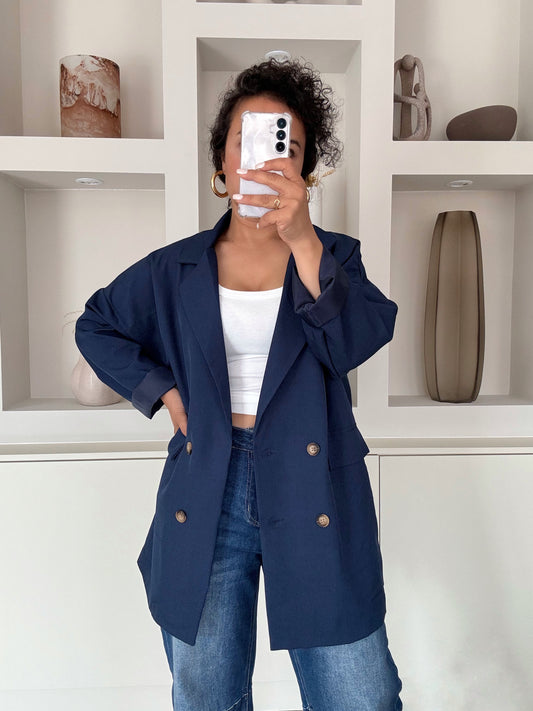 dubbelrijige blazer met ruime fit en knopen, gedragen over witte top en jeans – VYNAH