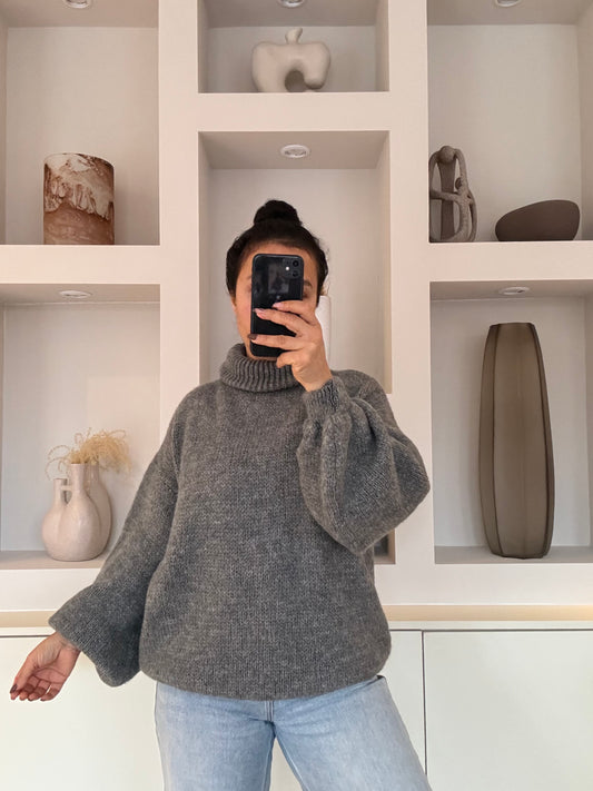 Model draagt de Estée Turtleneck, een zachte oversized coltrui in one size met een comfortabele knit en relaxed fit.